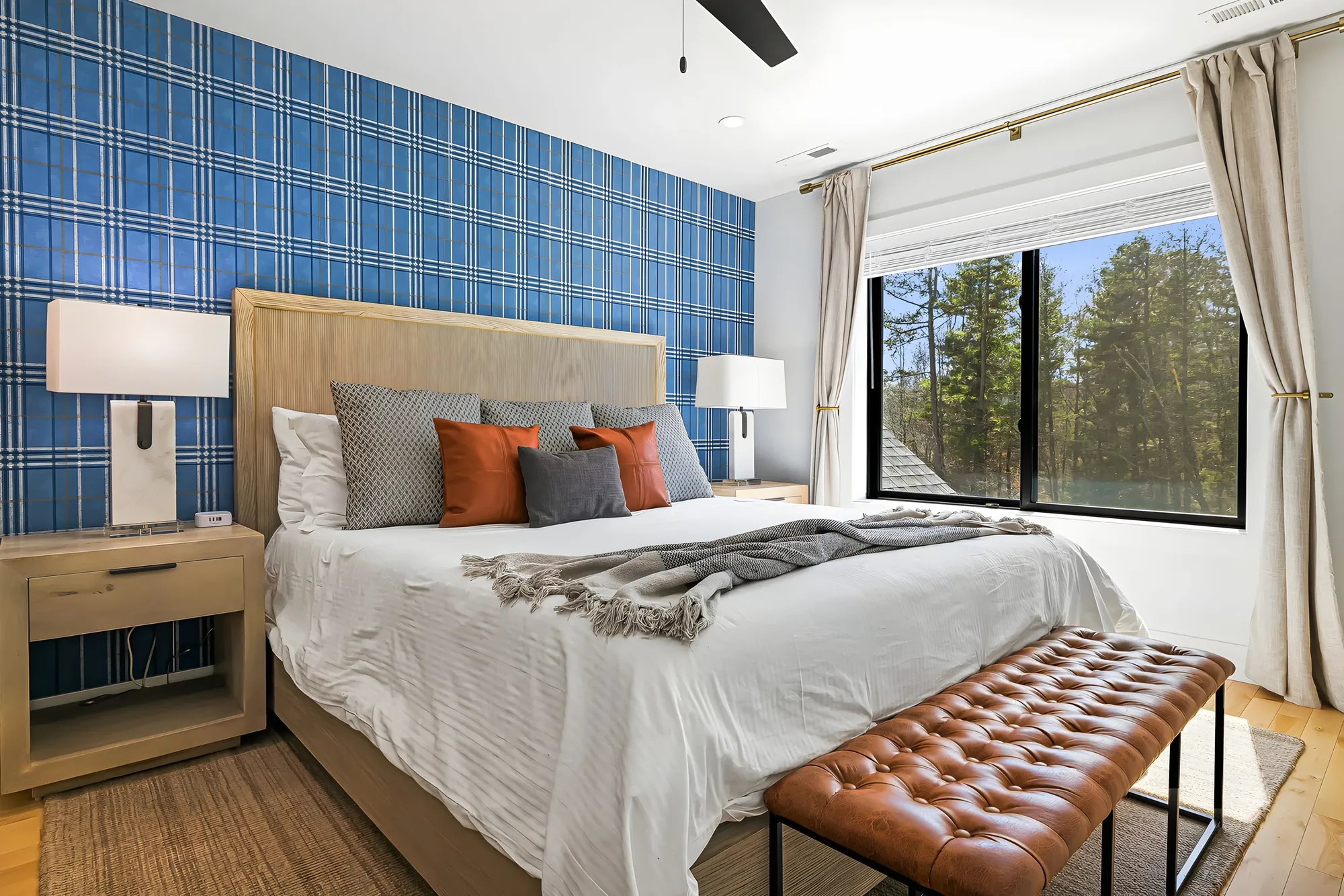 Guest bedroom at Ridge Glen with blue tile wallpaper, a made bed, and a leather bench