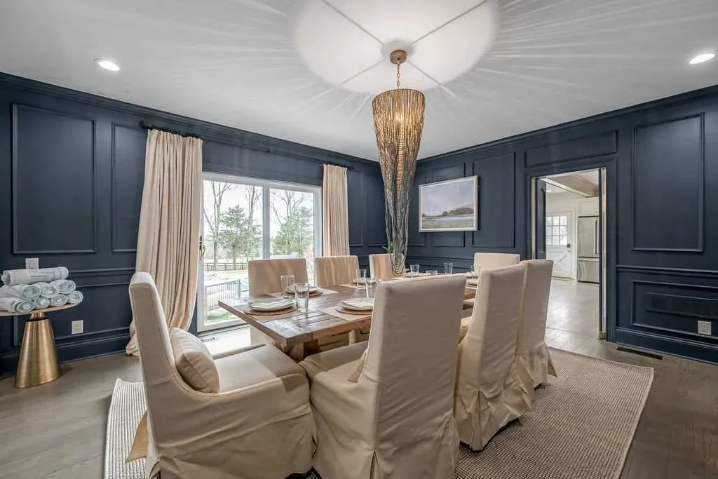 Navy dining room on Shelbyville Road with a set table, a chandelier, and a bar cart
